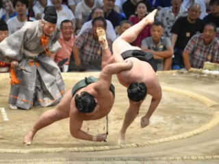Combining speed and strength, a rikishi (wrestler) forces his opponent out of a circular ring (dohyō)