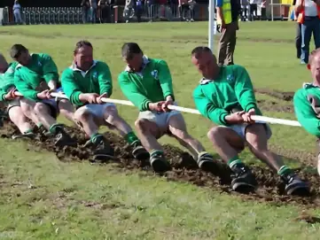 Две команды соревнуются друг с другом в испытании на силу и выносливость во время перетягивания каната